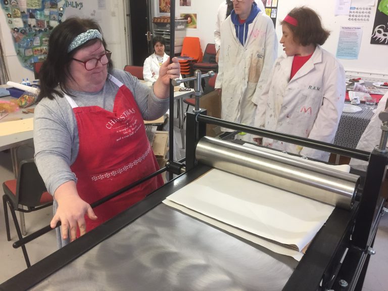 Image from Headway Arts Printable Project showing a participant at the printing press.